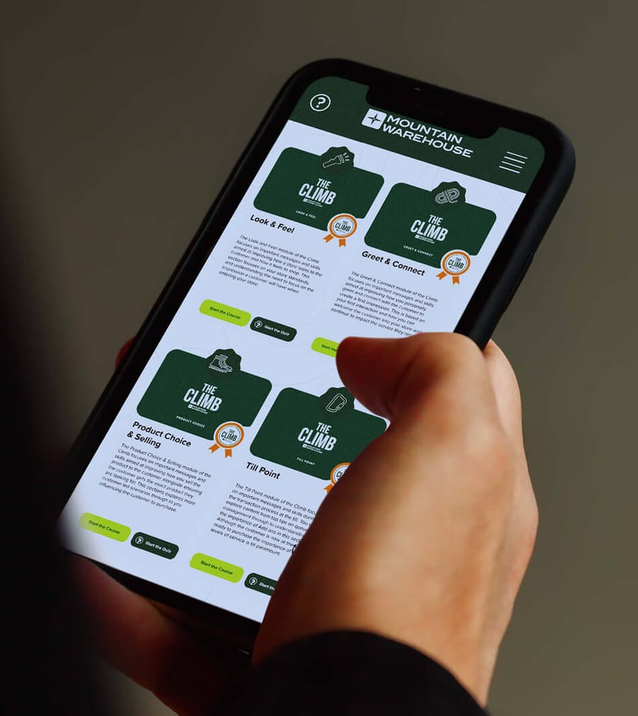 Mountain Warehouse The Climb app screen held in hand showing course module cards, app and brand design by On Poynt Creative