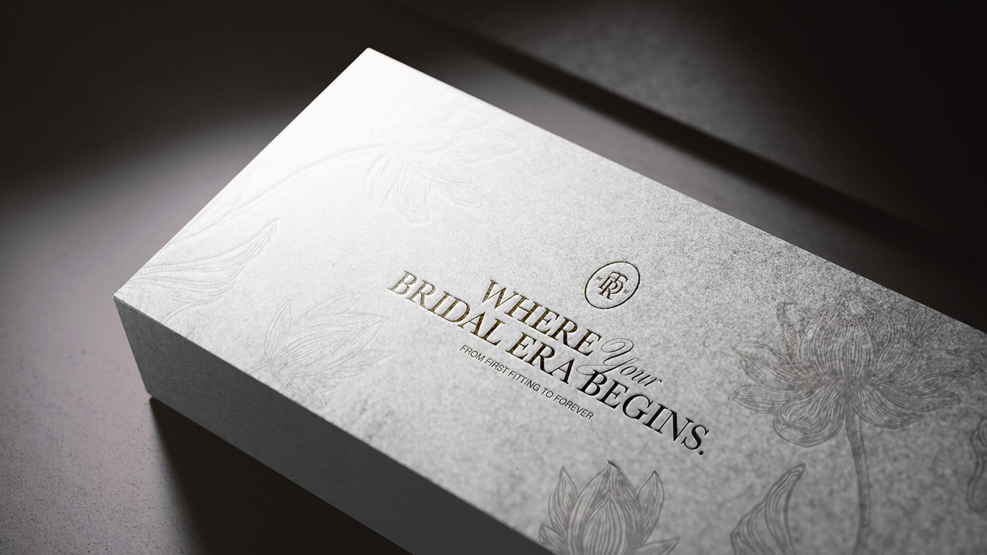 The Dressing Room Bridal embossed packaging box with 'Where Your Bridal Era Begins' branding and floral engraving, brand design by On Poynt Creative
